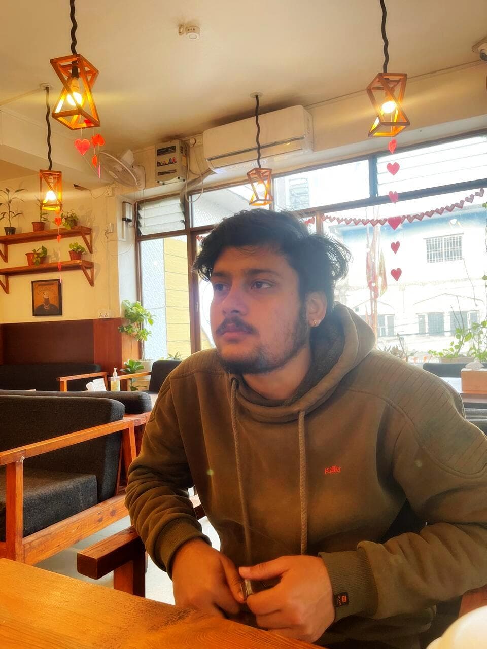 Portrait of Rohan Poudel seated in a cafe.